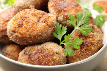 Tasty meat patties with parsley o wooden table, closeup