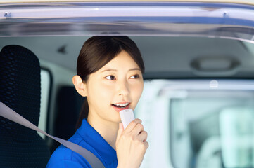 アルコールチェックする女性ドライバー　トラックの運転手