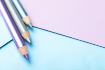 Colorful eye pencils on color background, closeup. Space for text
