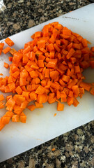 Diced carrots on cutting board in kitchen
