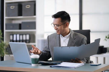 Male businessman using a tablet and computer to analysis graph company financial in office.