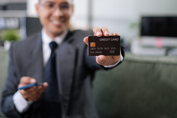 Hands holding credit card and using smartphone and laptop in office home. Online shopping.