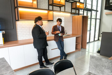 Two Sharp Dressed Businessmen Talking Shop During Break In Modern Office Kitchen Area