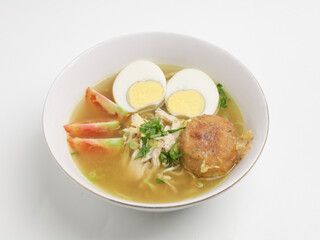 Soto Ayam or chicken soup cooked in chicken broth served with boiled egg, shredded chicken, bean sprout, fried mashed potato