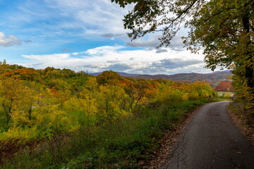 Country road in hilly landscape on an autumn evening