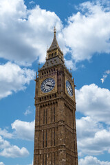 Elizabeth Tower clock in London against blue sky and clouds, iconic UK landmark