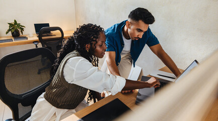 Two young architects collaborating on a project in a modern office space