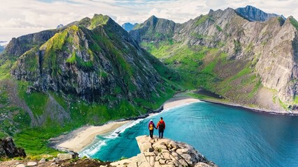 Two hikers admire the stunning landscape from Ryten peak, gazing at the turquoise waters of...