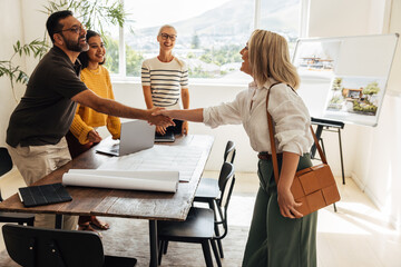 Architects greeting a client during a professional meeting at the firm