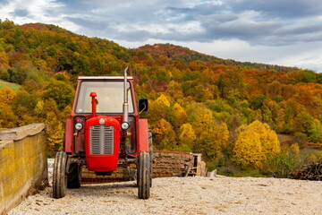 Red tractor in front of colorful autumn hills