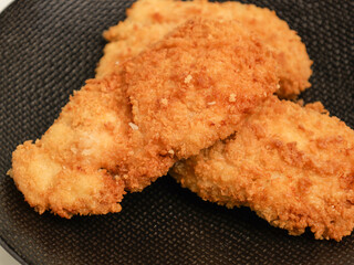 Chicken Katsu on black plate and white background
