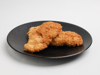 Chicken Katsu on black plate and white background