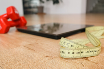 Fitness motivation - dumbbells, measuring tape, and scale for weight loss goals