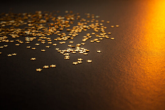 &Eacute;toiles dor&eacute;es sur fond brun, &eacute;toiles &agrave; gauche de l'image et rayon de lumi&egrave;re dor&eacute;e &agrave; droite de l'image, arri&egrave;re-plan de No&euml;l