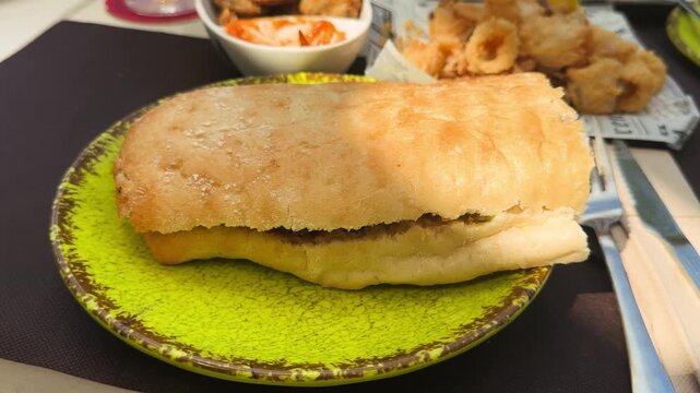 Bocadillo close up. Sandwich made with Spanish bread, baguette cut lengthwise with chicken breast and cheese. High quality 4k footage
