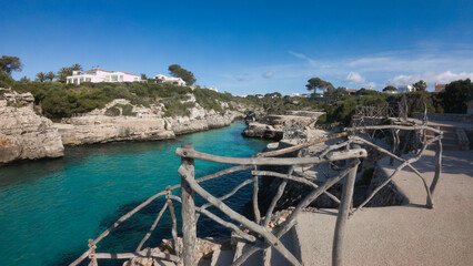 Naklejka premium A beautiful bbeach with a wooden fence surrounding it cala en brut menorca