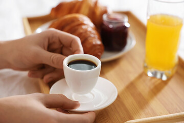 Man having breakfast in bed, closeup. Hotel room service