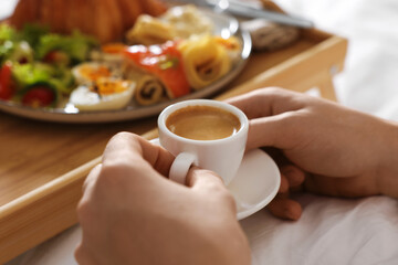Man having breakfast in bed, closeup. Hotel room service