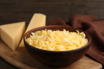 Grated and pieces of cheese on wooden table, closeup