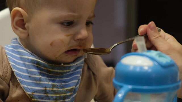 Baby with Food-Stained Face in High Chair