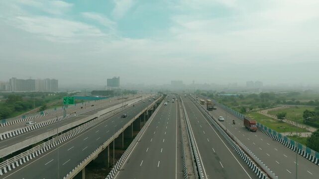 Aerial view of the Dwarka Expressway cutting through the landscape, with vehicles flowing smoothly on the multiple lanes, Gurugram, Haryana, India.