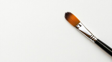 Paintbrush lying flat on clean paper in serene studio setting