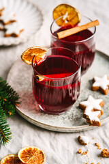 Zwei Gläser Glühwein mit Zimt und Orange und Zimtsterne auf einem Tablett. Weihnachten, Heißgetränk, Alkohol.