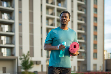 African man going to yoga class in urban setting