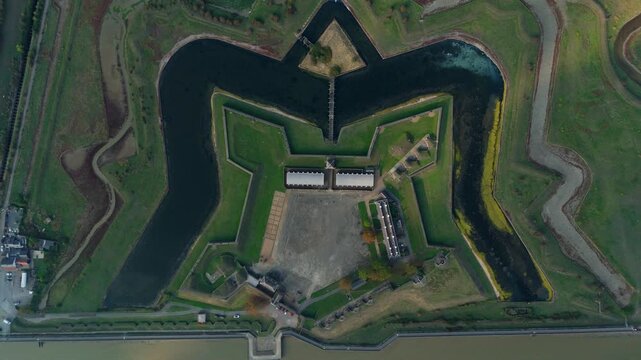 Aerial view of Tilbury Fort, a star-shaped fortress with green grass, surrounded by a dark moat, creating a striking contrast, Tilbury, England, United Kingdom.