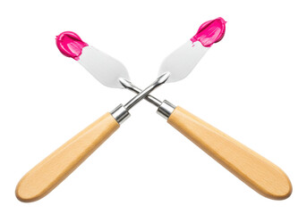 Isolated paint spatulas crossed with pink paint - wooden handle, artist studio, crafting