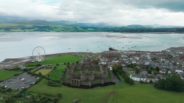 Beaumaris⁩, Wales, Castle Static with town, Manai Strait and mountains in the background