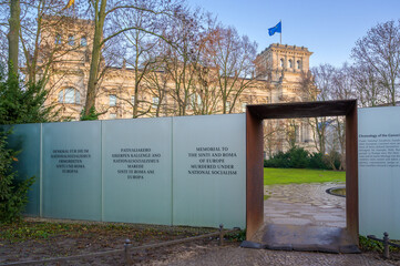 Berlin, Germany - December 20, 2019: Memorial honoring Sinti and Roma stands beside Reichstag Building in early morning light