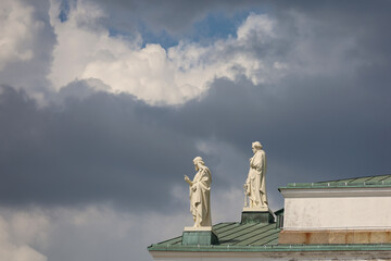 Obraz premium Two statues of the apostles on the roof of Helsinki Cathedral against a dramatic cloudy sky