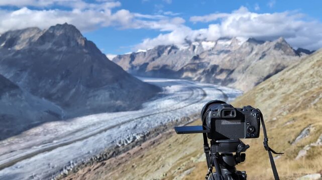 Professional camera filming glacier in Swiss mountains on a windy day, Aletsch glacier