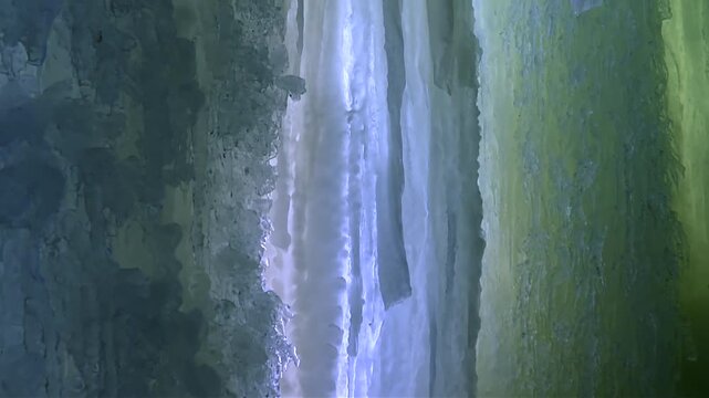 Inside the Eben Ice Caves in Michigan, close up view of thick vertical ice walls appear in striking blue and yellow hues