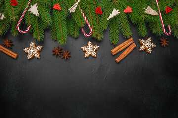 Christmas background with gingerbread cookies, cinnamon sticks, anise stars, fir branches and candy...