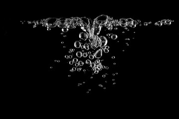 Obraz premium Clear water bubbles rising in black background, creating clean and refreshing,symbolizing purity, freshness, oxygen, and natural element concept for design, advertising, or background use.