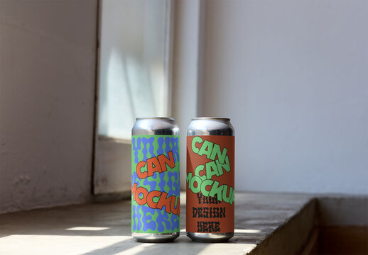 Two blank cans sit on a windowsill