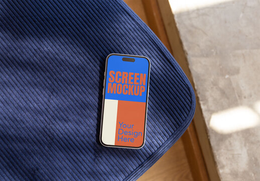 A smartphone rests on a textured fabric surface