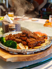 Chinese-style sizzling beef with onions served hot on a metal plate