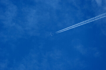 Contrail and clouds. Airplane trail in the blue sky with white clouds and copy space