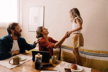 Family moment: parents play with daughter at home
