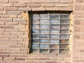 beige brick wall with glass block window