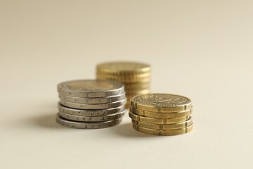 Saving money. Coins on beige background, closeup