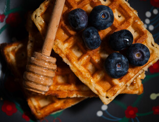Ripe Blueberries on waffles with honey macro