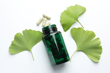 Ginkgo biloba leaves and pills on white background, flat lay