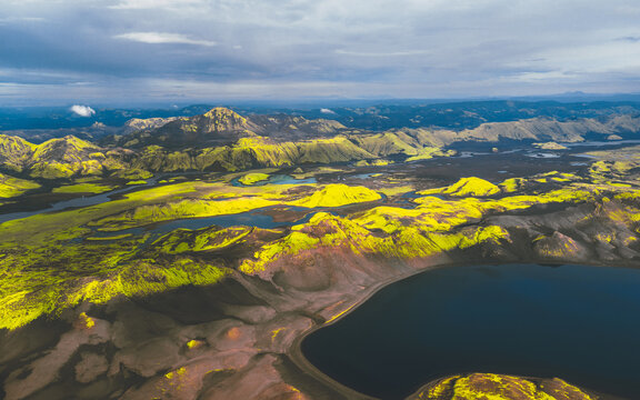 Aerial view of a vibrant landscape where emerald moss clings to the volcanic terrain amidst dark waters under a dramatic sky, Lakag&Atilde;&shy;gar, Skaft&Atilde;&iexcl;rhreppur, Iceland.