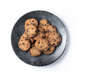 Baked chocolate chip cookies on black plate isolated on white background. Top view. Copy space