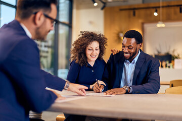 Couple Signing Documents And Discussing Plans In Modern Office