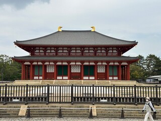 Obraz premium Traditional Japanese temple hall with red pillars and yellow roof decorations in Nara, Japan